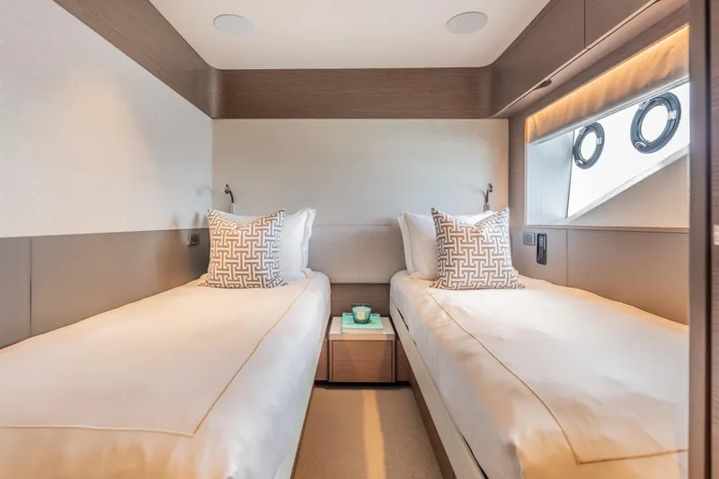 Gemini Yacht Photos Pics Luxurious twin cabin interior on 2023 Princess X95 yacht, featuring elegant bedding and modern design.