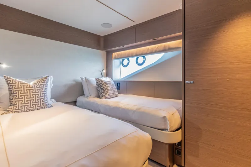 Gemini Yacht Photos Pics Luxurious twin cabin interior on 2023 Princess X95 yacht, featuring elegant bedding and modern design.