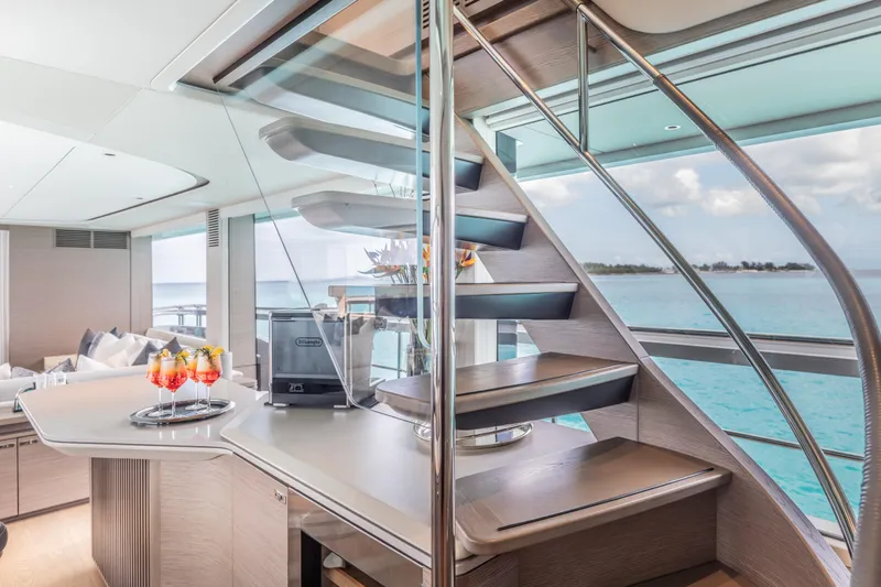 Gemini Yacht Photos Pics Luxurious interior of 2023 Princess X95 yacht with modern staircase and ocean view.