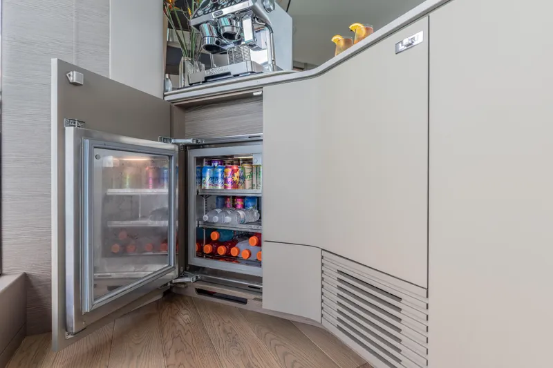 Gemini Yacht Photos Pics Luxury yacht Princess X95 interior with open mini fridge stocked with beverages, 2023 model.