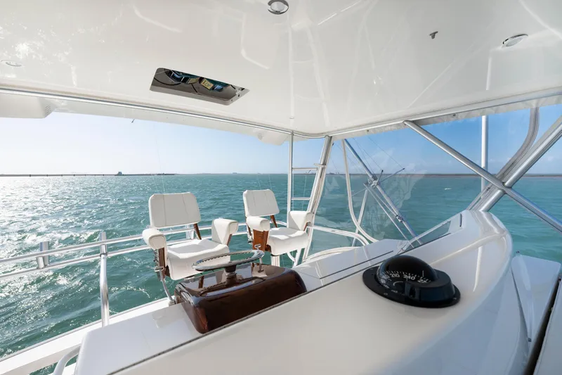  Yacht Photos Pics 2008 Viking Convertible yacht helm with ocean view, featuring white captain chairs and navigation equipment.