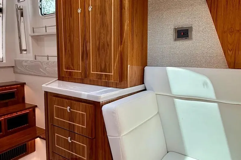  Yacht Photos Pics Luxurious interior of 2025 HCB 48 Campeon yacht with wood cabinetry and white seating.