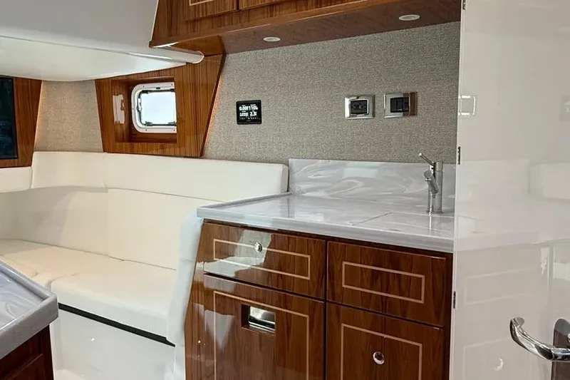  Yacht Photos Pics Luxurious interior of 2025 HCB 48 Campeon yacht with wood cabinetry and white seating.