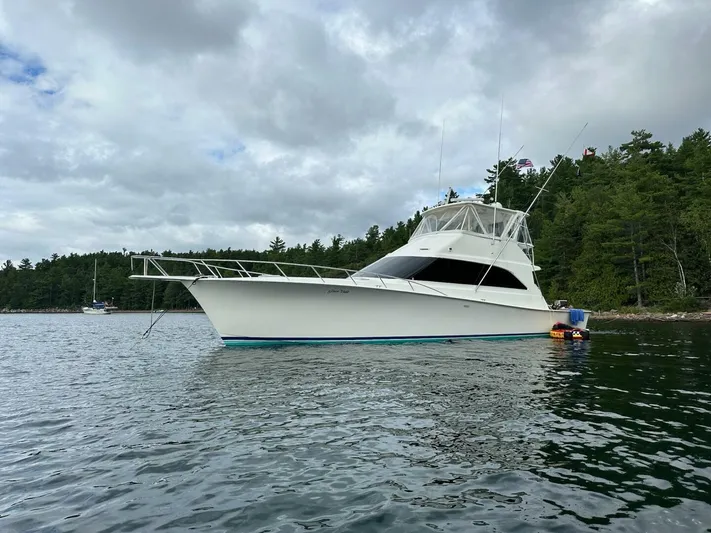 Gran Vida Yacht Photos Pics 1998 Ocean Yachts Super Sport boat anchored on a calm lake with forested shoreline.