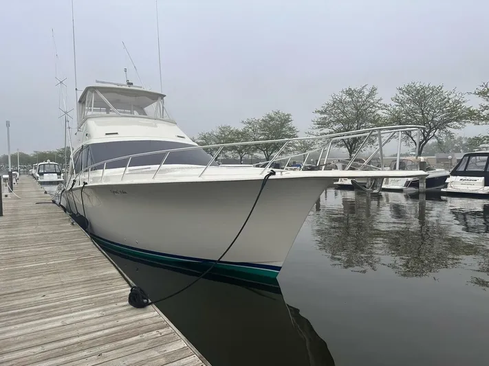 Gran Vida Yacht Photos Pics 1998 Ocean Yachts Super Sport docked at marina, overcast sky, calm water.