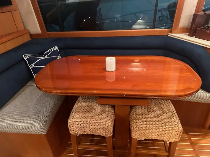 Gran Vida Yacht Photos Pics Luxurious 1998 Ocean Yachts Super Sport interior with elegant wooden dining table and cushioned seating.