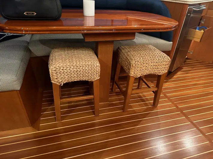 Gran Vida Yacht Photos Pics Interior of 1998 Ocean Yachts Super Sport with wooden table and woven stools.
