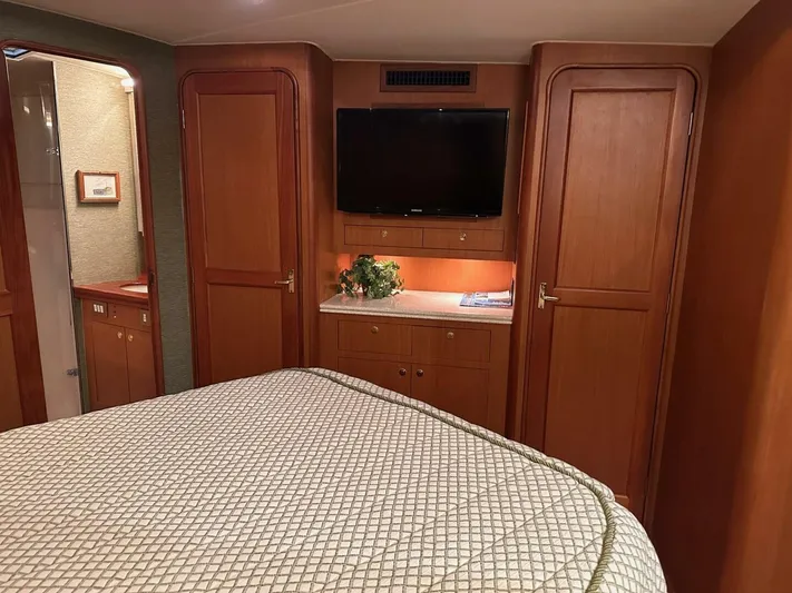 Gran Vida Yacht Photos Pics Luxurious 1998 Ocean Yachts Super Sport cabin interior with TV and wooden cabinetry.