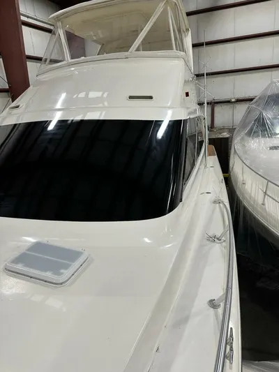 Gran Vida Yacht Photos Pics 1998 Ocean Yachts Super Sport boat in storage, showcasing sleek design and white exterior.