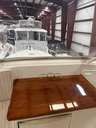 Gran Vida Yacht Photos Pics 1998 Ocean Yachts Super Sport interior with polished wood table in a boat storage facility.