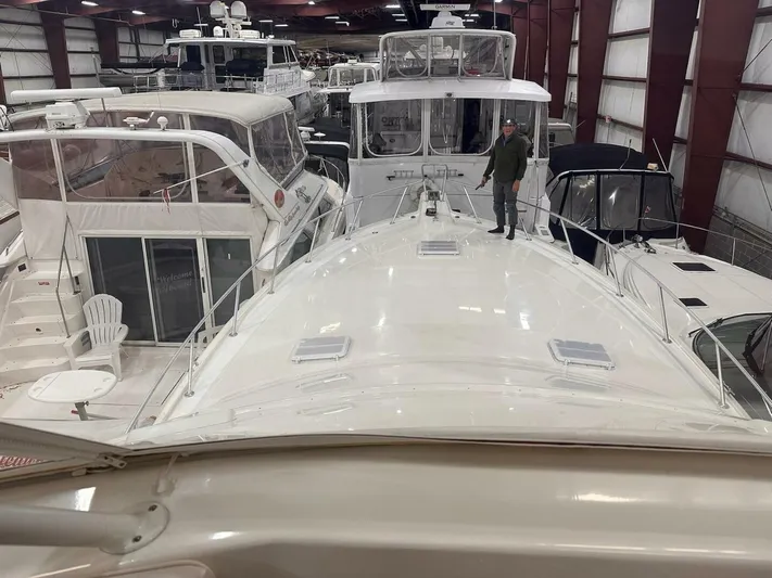 Gran Vida Yacht Photos Pics Man standing on 1998 Ocean Yachts Super Sport in indoor marina.