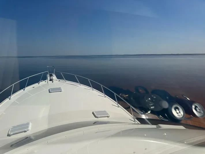 Gran Vida Yacht Photos Pics Bow view of 1998 Ocean Yachts Super Sport on calm water under clear sky.