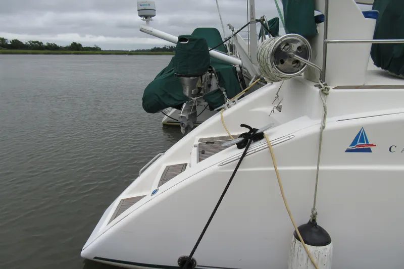 Pippin Yacht Photos Pics Catana 471 catamaran from 2001 docked on a calm river with overcast skies.