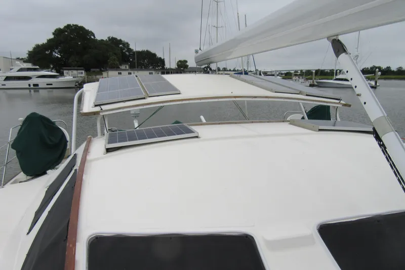 Pippin Yacht Photos Pics Catana 471 catamaran (2001) with solar panels on deck, docked in a marina.