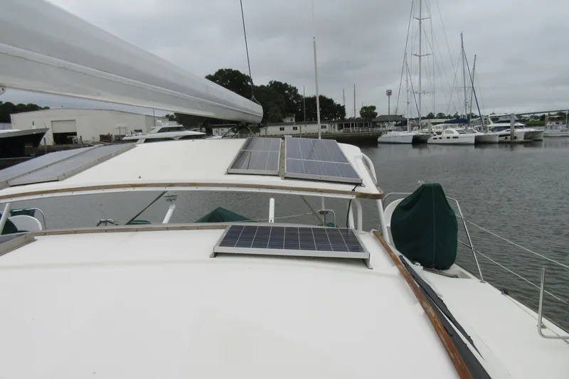 Pippin Yacht Photos Pics Catana 471 sailboat from 2001 with solar panels, docked in a marina.