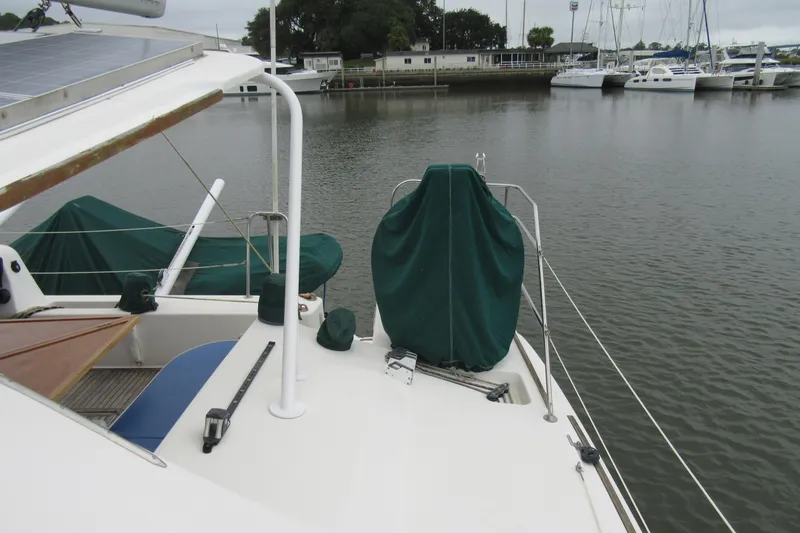 Pippin Yacht Photos Pics 2001 Catana 471 yacht docked at marina, featuring covered equipment and solar panels.