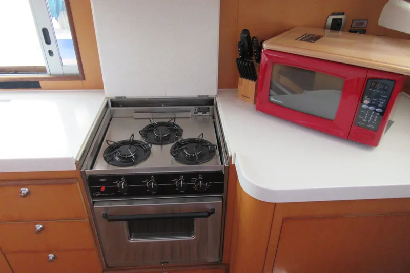 Pippin Yacht Photos Pics Galley kitchen in 2001 Catana 471 yacht with stove and red microwave.