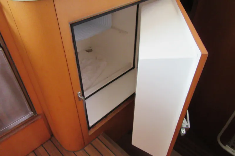 Pippin Yacht Photos Pics Open storage compartment on 2001 Catana 471 yacht, featuring wooden interior design.