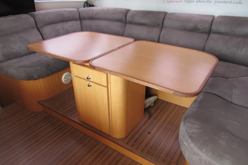 Pippin Yacht Photos Pics Interior of 2001 Catana 471 yacht with wooden table and cushioned seating.