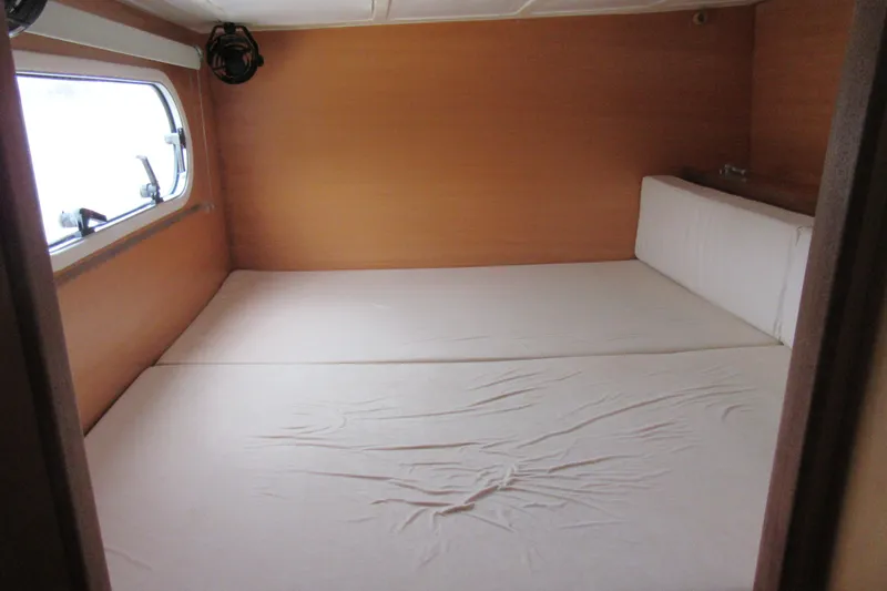 Pippin Yacht Photos Pics Interior cabin of 2001 Catana 471 yacht with a spacious bed and window.