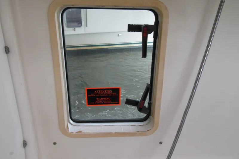 Pippin Yacht Photos Pics Window view from 2001 Catana 471 sailboat, showing water and safety warning label.