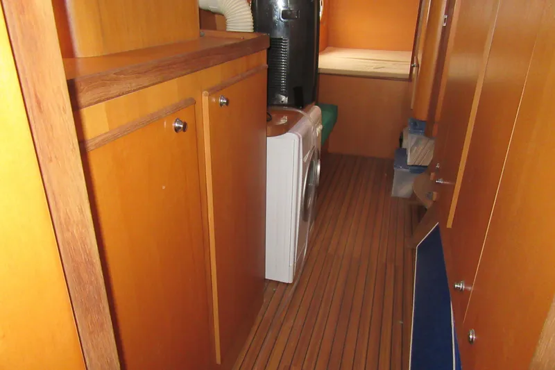 Pippin Yacht Photos Pics Interior of 2001 Catana 471 yacht with wooden cabinets and washing machine.