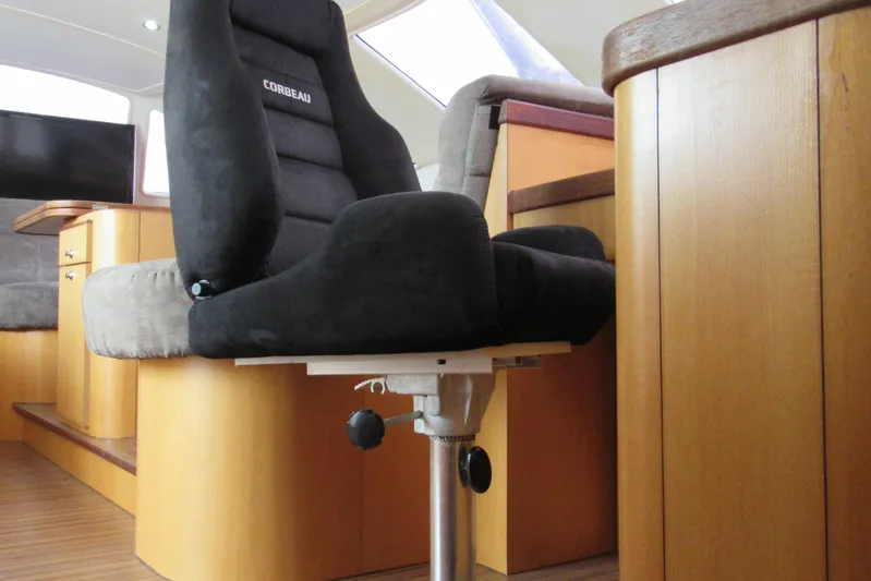 Pippin Yacht Photos Pics Interior of 2001 Catana 471 yacht featuring a Corbeau captain's chair and wooden cabinetry.