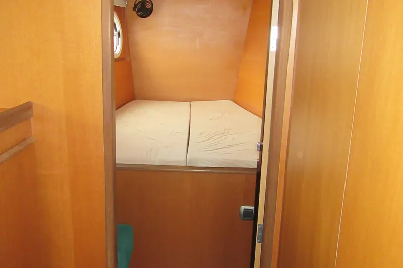 Pippin Yacht Photos Pics Cozy cabin interior of 2001 Catana 471 yacht with wooden finish and bed.