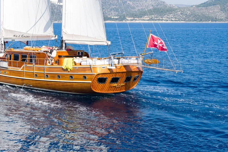 Take It Easier Yacht Photos Pics Custom 2007 Gulet Motorsailer sailing on clear blue sea with white sails.