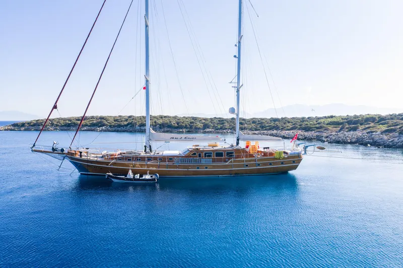 Take It Easier Yacht Photos Pics Custom 2007 Gulet Motorsailer anchored in serene blue waters, with lush coastline backdrop.