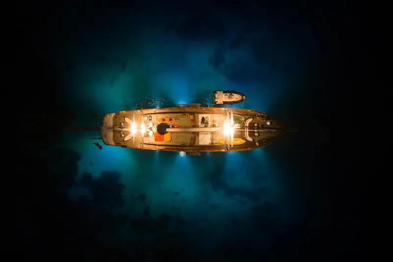 Take It Easier Yacht Photos Pics Aerial view of illuminated 2007 Custom Gulet Motorsailer at night on dark water.