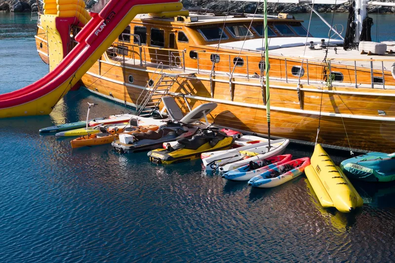 Take It Easier Yacht Photos Pics Custom 2007 Gulet Motorsailer with water toys and slide in a serene harbor setting.