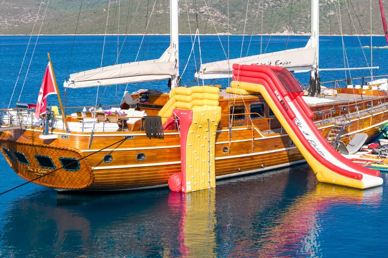 Take It Easier Yacht Photos Pics Custom 2007 Gulet Motorsailer with inflatable slide and climbing wall on blue water.