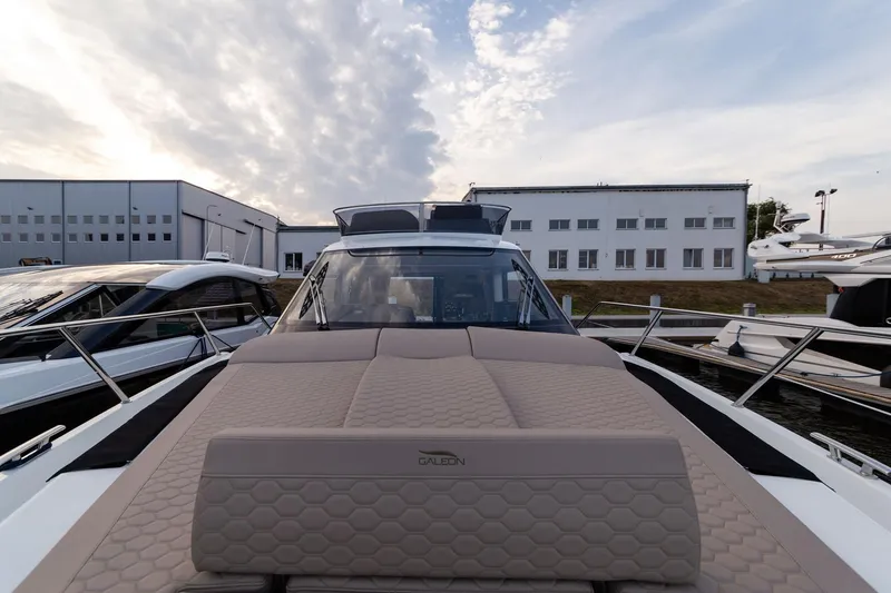  Yacht Photos Pics 2024 Galeon 400 Fly yacht with sleek design, docked near modern buildings.