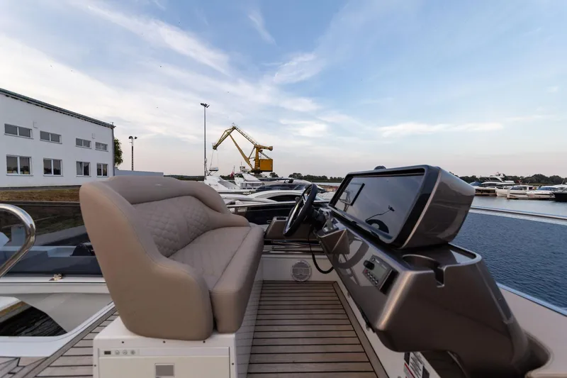  Yacht Photos Pics 2024 Galeon 400 Fly yacht helm with modern controls and comfortable seating at a marina.