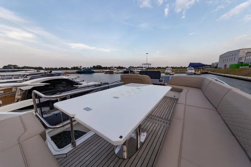  Yacht Photos Pics 2024 Galeon 400 Fly yacht deck with seating and table, docked at marina.