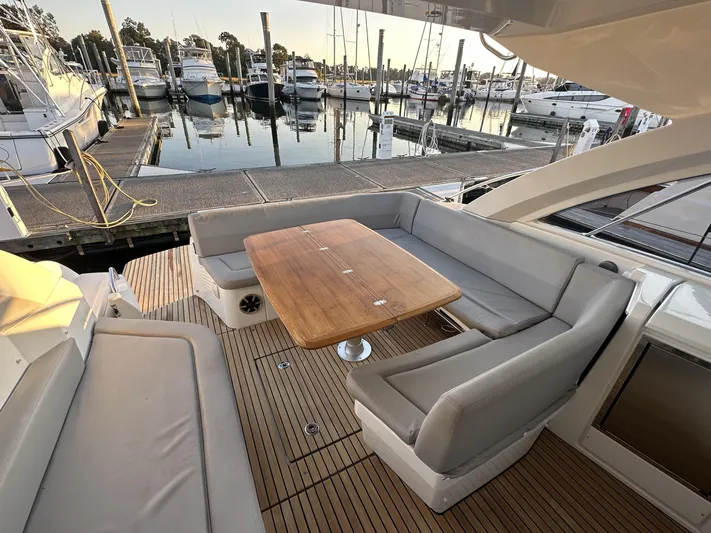 Yacht Photos Pics 2013 Beneteau Gran Turismo 38 yacht with spacious outdoor seating and wooden table at marina.