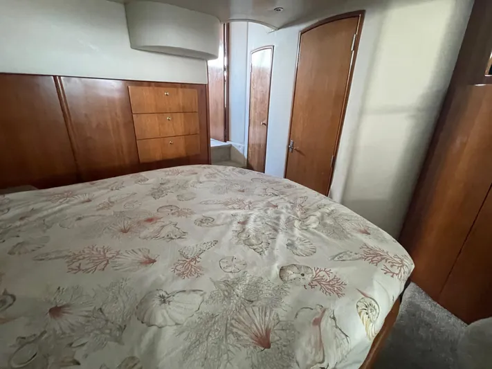 Sudden Comfort Yacht Photos Pics 2001 Carver 444 Cockpit Motor Yacht bedroom with wood cabinetry and patterned bedspread.