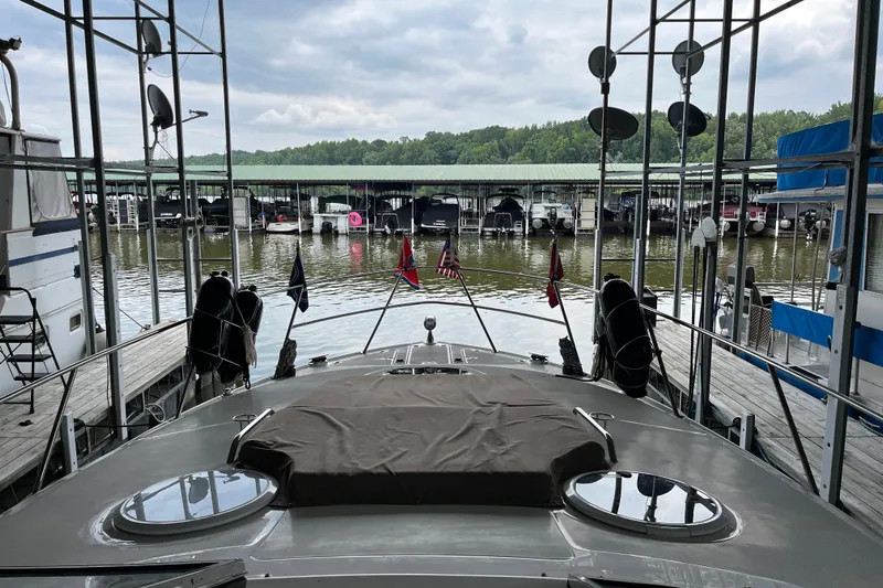 River Dancer Yacht Photos Pics 2007 Regal 3760 IB COMMODORE yacht docked at marina with covered boats and lush greenery.