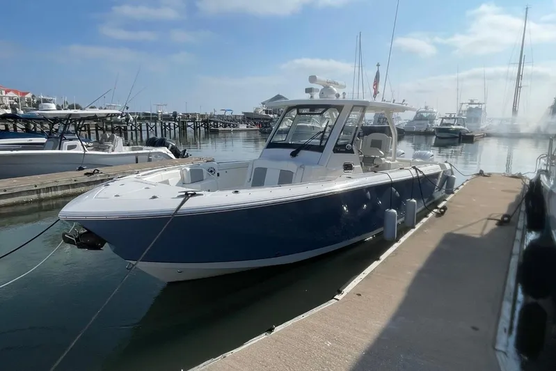 Equanimity Yacht Photos Pics 2021 Pursuit S 328 Sport boat docked at a marina under a clear sky.
