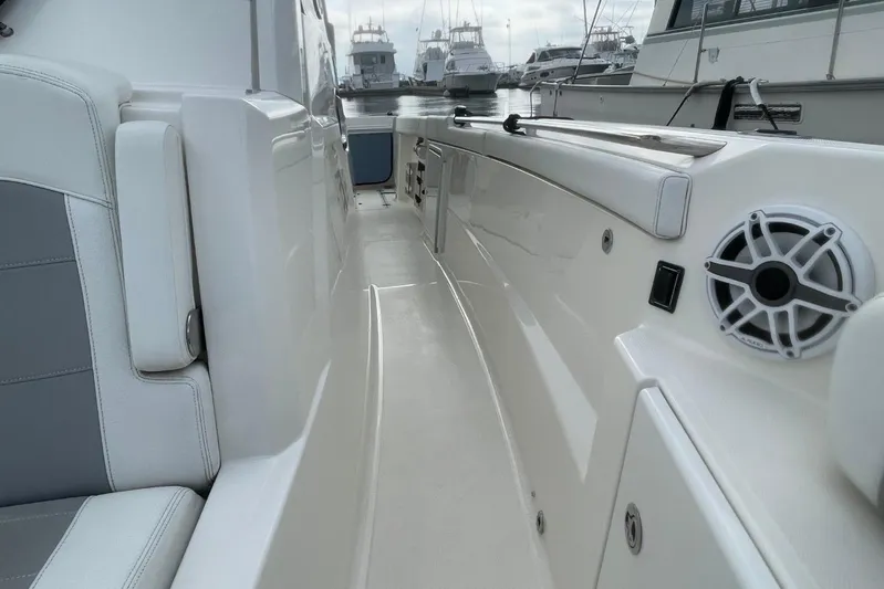 Equanimity Yacht Photos Pics 2021 Pursuit S 328 Sport boat interior with seating and speaker, docked at marina.