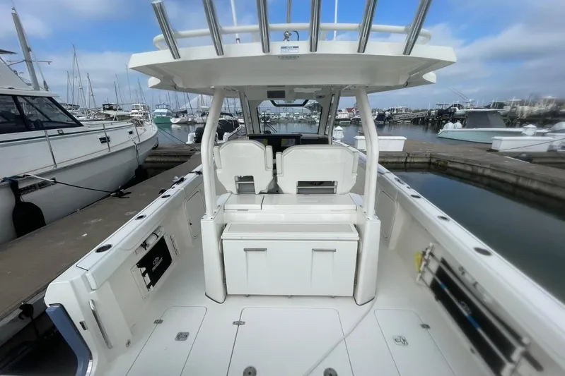 Equanimity Yacht Photos Pics 2021 Pursuit S 328 Sport boat interior at marina, showcasing seating and storage.