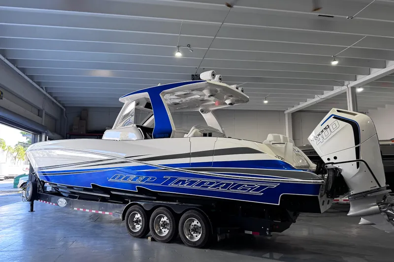  Yacht Photos Pics 2024 Deep Impact 399 Sport boat in a showroom, featuring sleek blue and white design.