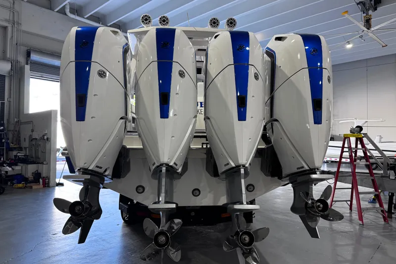  Yacht Photos Pics 2024 Deep Impact 399 Sport boat with four powerful outboard engines in a garage setting.