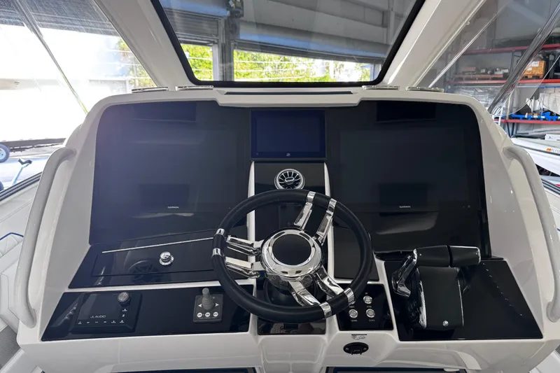  Yacht Photos Pics 2024 Deep Impact 399 Sport boat dashboard with modern controls and steering wheel.