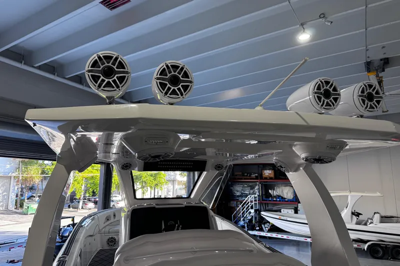  Yacht Photos Pics 2024 Deep Impact 399 Sport boat with advanced audio system in a garage setting.