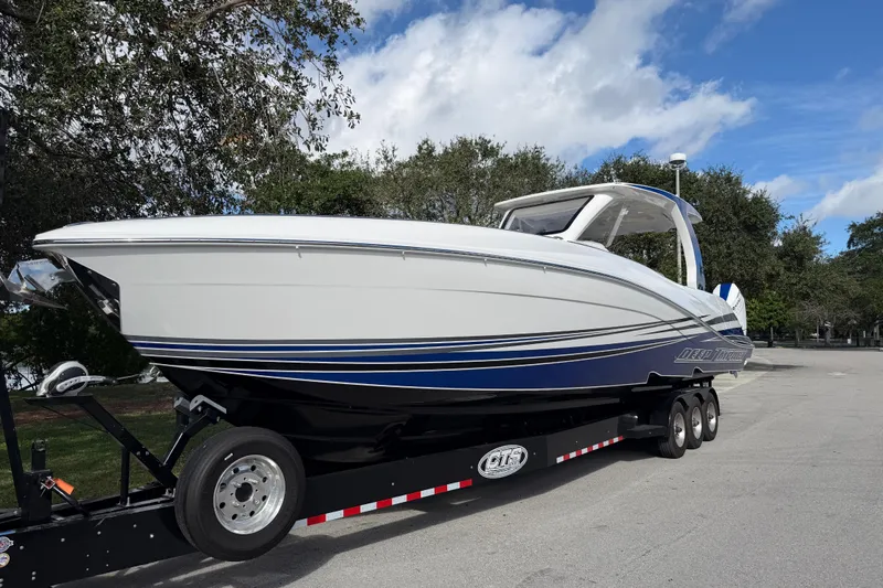  Yacht Photos Pics 2024 Deep Impact 399 Sport boat on trailer, sleek design, white and blue accents.