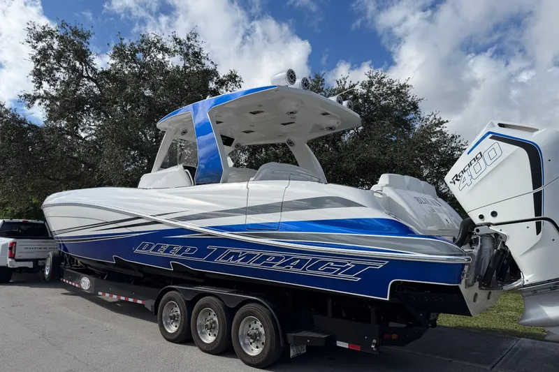  Yacht Photos Pics 2024 Deep Impact 399 Sport boat with blue and white design on a trailer.