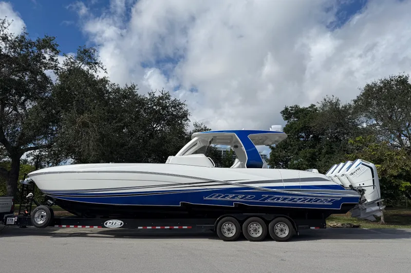  Yacht Photos Pics 2024 Deep Impact 399 Sport boat on trailer, blue and white design, parked outdoors.