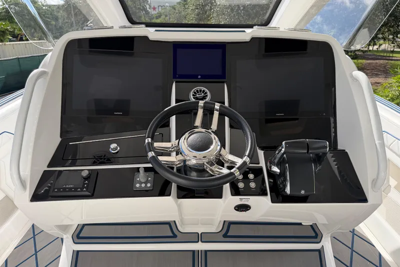  Yacht Photos Pics 2024 Deep Impact 399 Sport boat dashboard with modern controls and steering wheel.